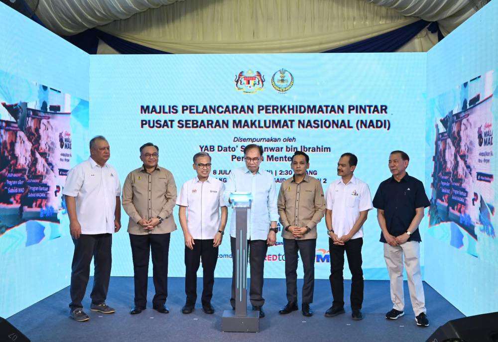 Anwar (empat dari kiri) menyempurnakan gimik perasmian Perkhidmatan Pintar NADI Kampung Dato' Ahmad Said Tambahan 2 pada Isnin.