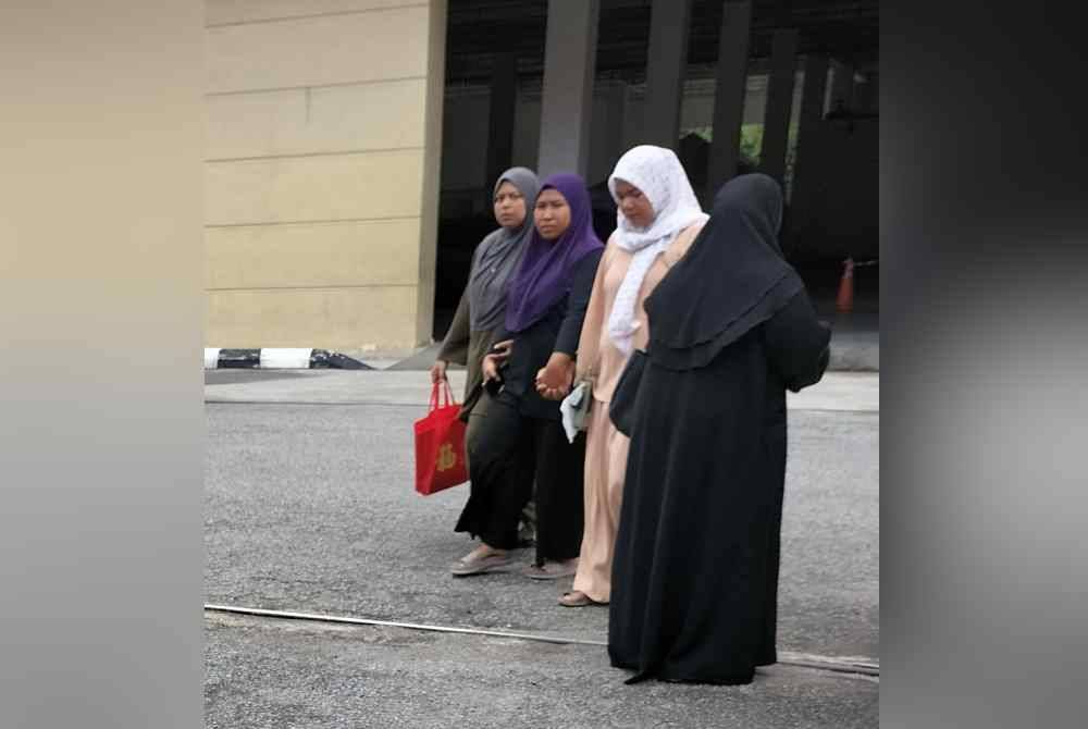 Nurain (dua dari kiri) ditemani saudaranya ketika tiba di Jabatan Forensik HPP pada Rabu.