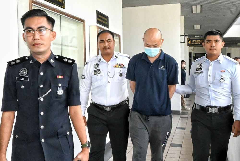 Sang Ken (dua dari kanan) ketika dibawa keluar dari Mahkamah Majistret pada Khamis.