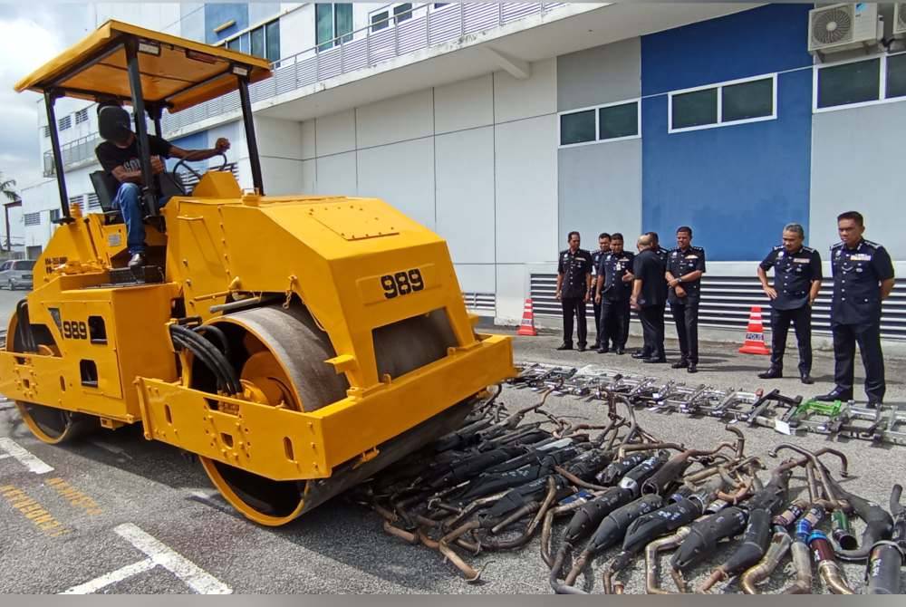 Fisol (kanan) melihat proses pelupusan aksesori motosikal diubahsuai di IPK Kedah pada Khamis.