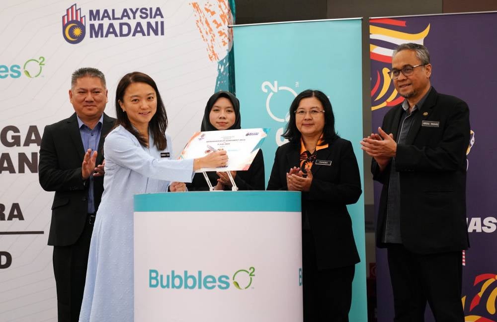 Hannah Yeoh (kiri) menandatangani plak dan disaksikan oleh Arifin (kiri), Ain (tiga dari kanan) serta Rashid (kanan) pada majlis itu.