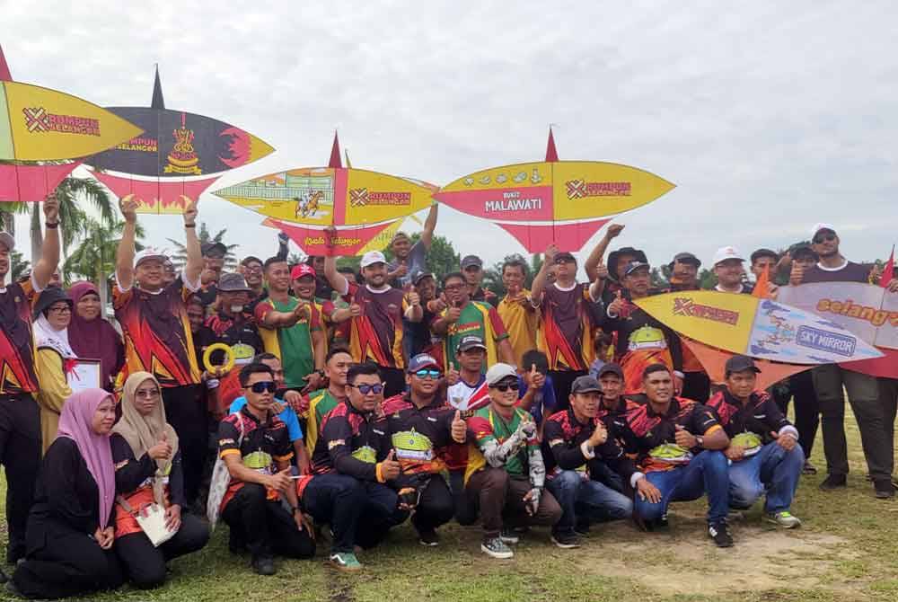 Tengku Amir (berdiri belakang) sambil memegang wau kapal bergambar bersama-sama tetamu yang hadir pada Program Pertunjukan Wau Kapal sempena Program Rumpun Selangor di SMK Kampung Bukit Kuching Tengah di sini pada Khamis.