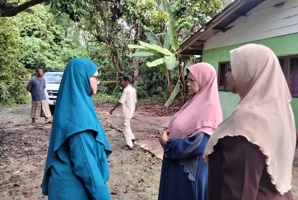 Samsiah (kiri) menerima kehadiran rakan dan keluarga selepas kebakaran yang mengakibatkan kematian ibu mertuanya.