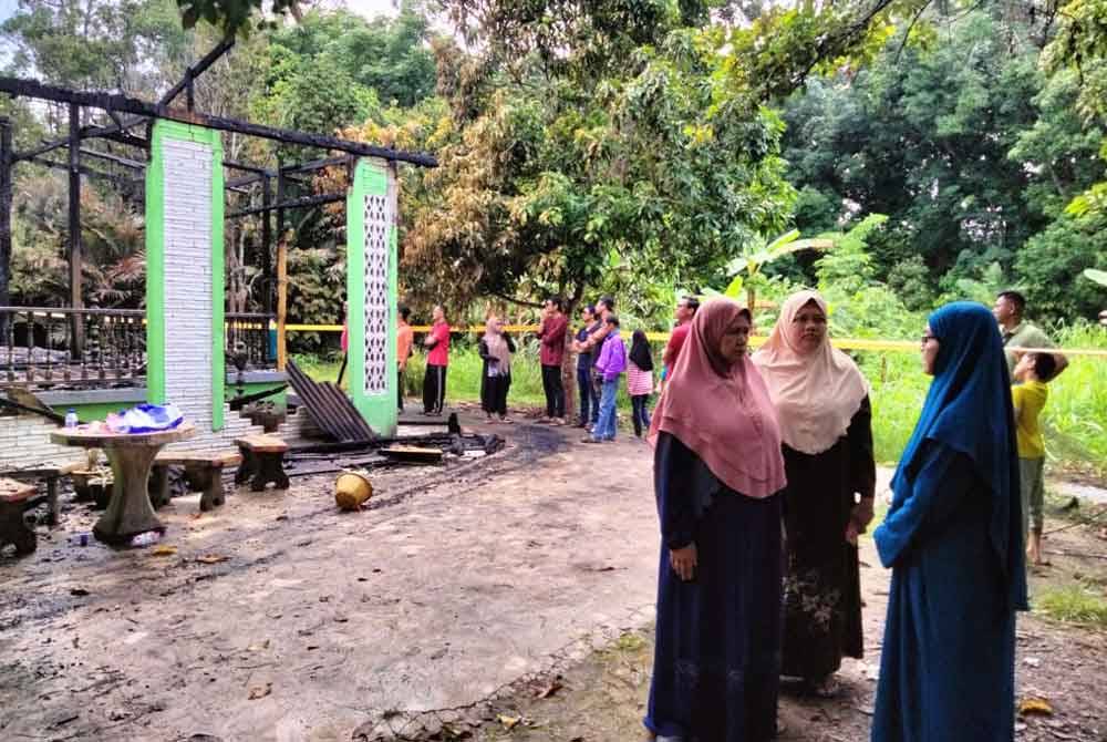 Samsiah (kanan) menerima kehadiran rakan dan keluarga selepas kebakaran yang mengakibatkan kematian ibu mertuanya.