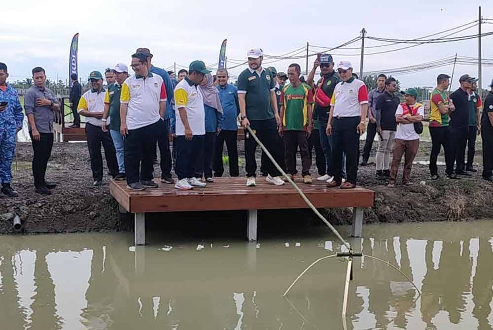 Tengku Amir Shah (dua dari kanan) berkenan mengancau ikan semasa lawatan baginda di
Taman Agroteknologi MARDI Tanjong Karang di sini pada Jumaat.
