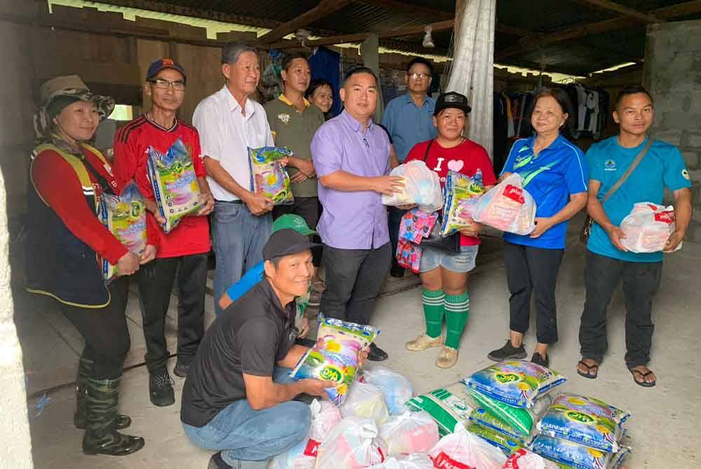Fardy (empat dari kanan) menyampaikan bantuan bakul makanan kepada penduduk Kampung Kolosunan, Inanam.