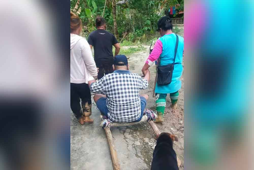 Penduduk kampung terpaksa memikul pesakit lalu di kawasan tanah runtuh untuk ke hospital.