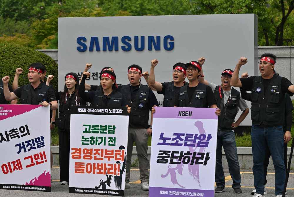 Wakil kesatuan melaungkan slogan ketika mengadakan protes di luar ibu pejabat Samsung Electronics di Seoul. Foto AFP