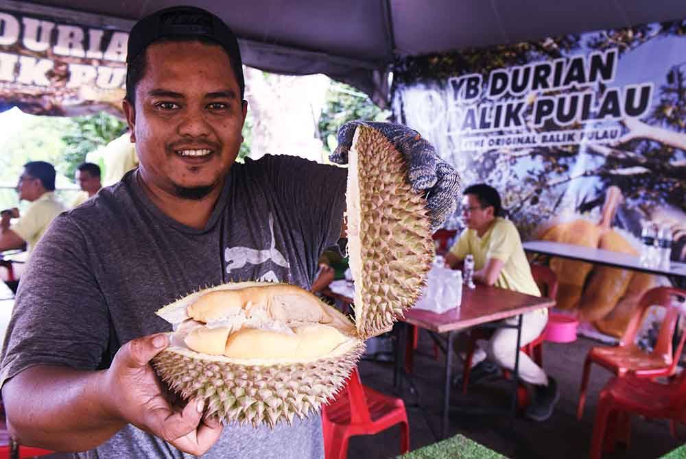 Mohd Shafiq Zainol menunjukkan buah durian yang dijual di Anjung Indah, Balik Pulau. Foto Bernama
