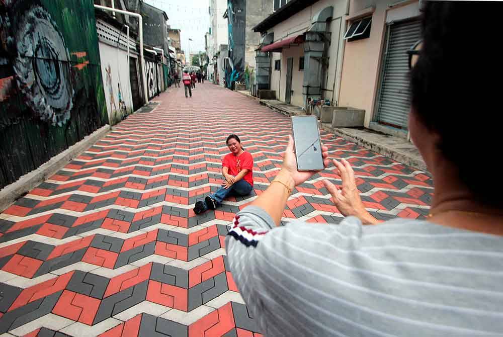 Pengunjung mengabadikan kenangan bergambar di Kuantan Art Street hari ini.