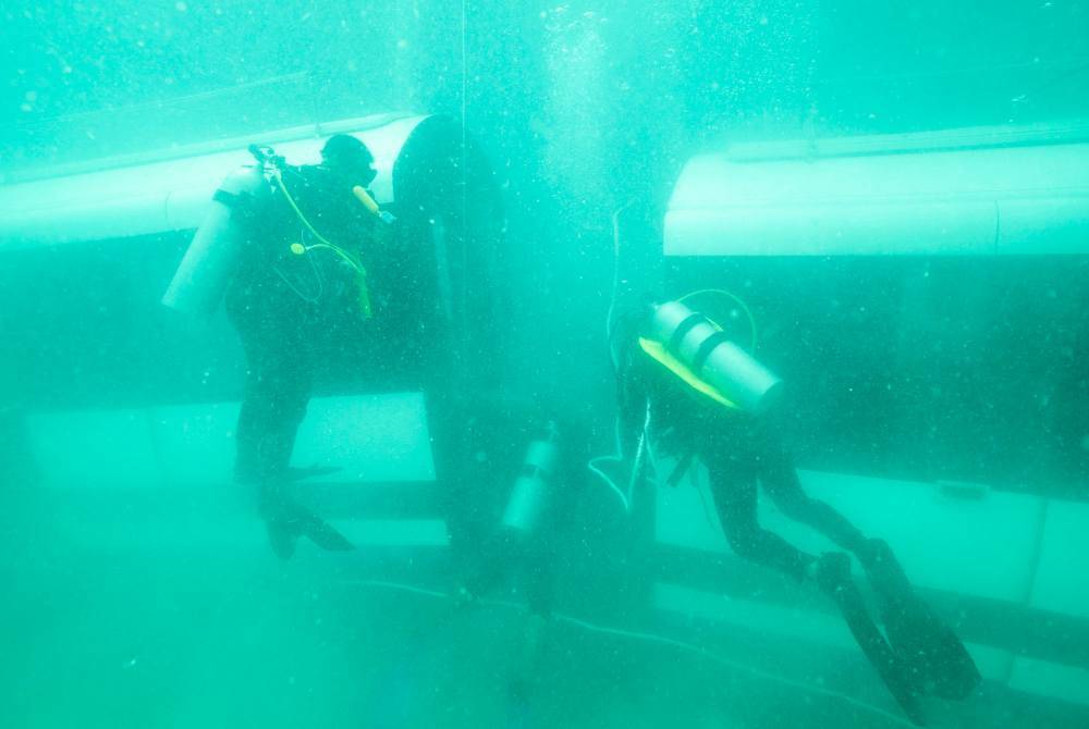 Usaha melabuhkan dua gerabak LRT itu melibatkan 60 penyelam. Foto Bernama