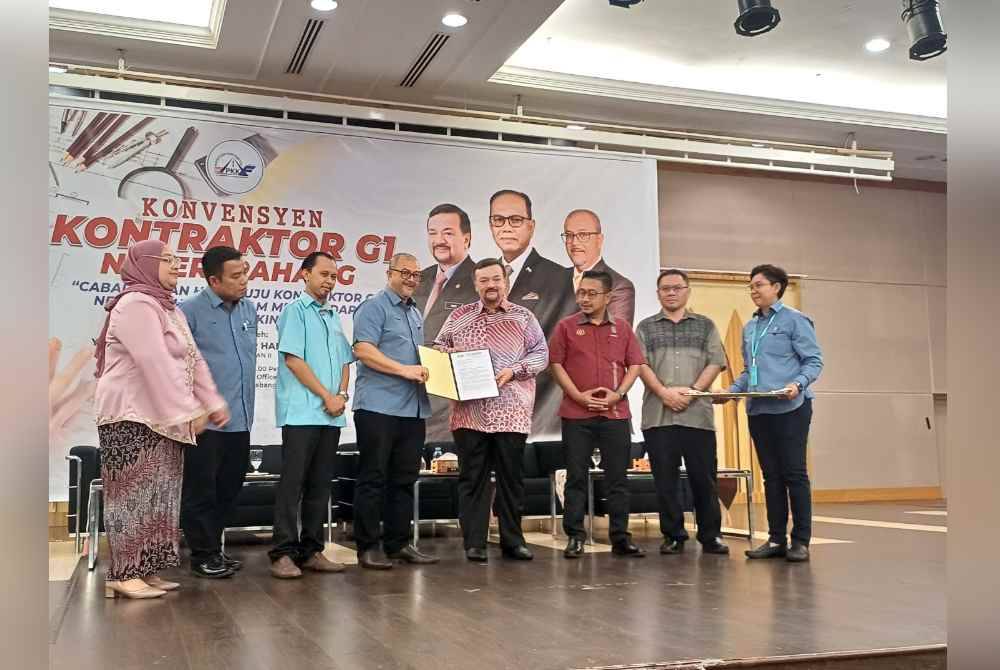 Amir Hamzah (empat dari kanan) menyampaikan sijil kepada wakil kontraktor pada Konvensyen Transformasi G1 anjuran Persatuan Kontraktor Kelas F Pahang di Dewan Utama, Pejabat Pengarah Kampus, Universiti Islam Antarabangsa Malaysia, di sini, pada Sabtu.