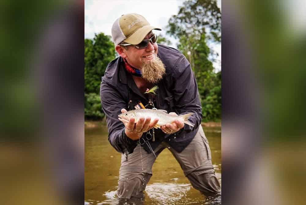 Christopher bersama ikan sikang yang ditangkap menggunakan teknik pancing layang di Sungai Berang, Hulu Terengganu.