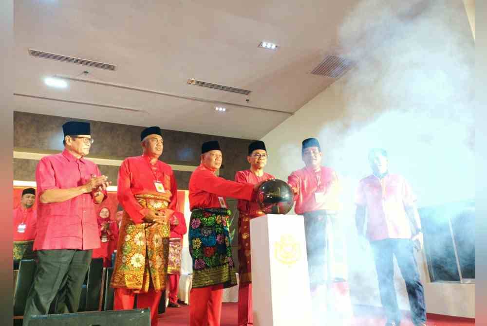 Mohamed Khaled (tiga dari kanan) menyempurnakan gimik perasmian Mesyuarat Perwakilan UMNO Bahagian Parit 2024 di D Hotel Seri Iskandar pada Ahad.