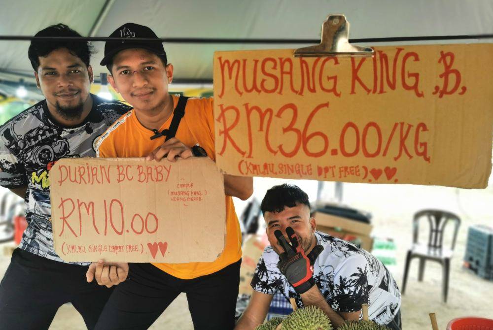 Ahmad Naqiuddin (tengah) bersama Zamadi (kiri) dan Muhammad Faqrullah di gerai jualan durian mereka di Kampung Seberang Takir, Kuala Nerus.