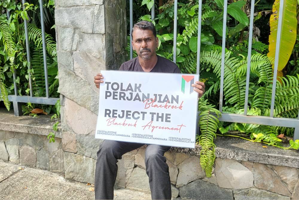 Mythreyar melakukan mogok lapar sambil memegang sepanduk di hadapan bangunan Parlimen sejak Rabu lalu.