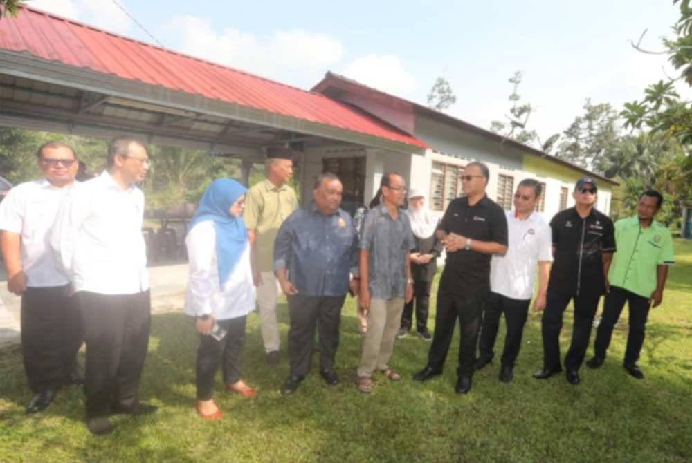 Isham (empat dari kanan) mengadakan lawatan ke rumah penduduk, Mohd Fuad Ehwal, 63, (lima dari kiri) pada Isnin. 