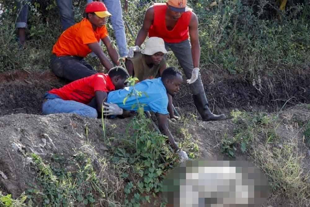 Sukarelawan membawa salah satu mayat mangsa pembunuh bersiri dari tapak pembuangan sampah di kawasan setinggan Mukuru, di Nairobi, Kenya. - Foto Reuters