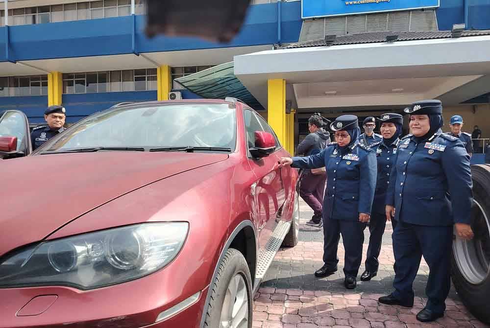 Norlela (kiri) menunjukkan antara kenderaan yang dirampas dalam serbuan di sebuah gudang di sekitar Lembah Klang, pada 26 Jun lalu.