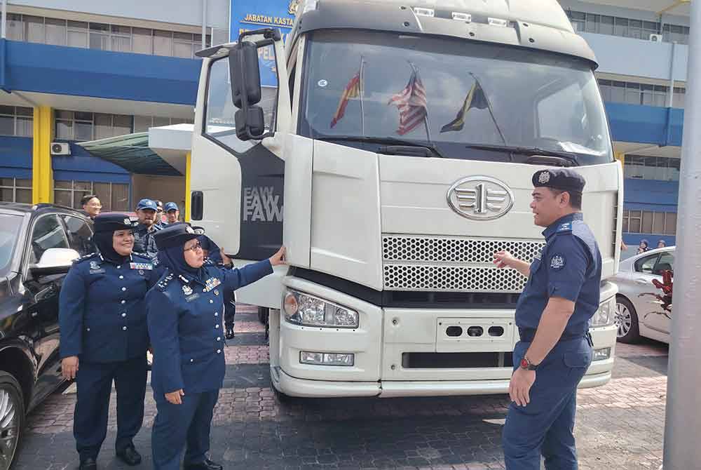 Norlela (tengah) menunjukkan kepala lori kontena yang dirampas dalam sebuah gudang di Pelabuhan Barat, Klang pada 3 Julai lalu.