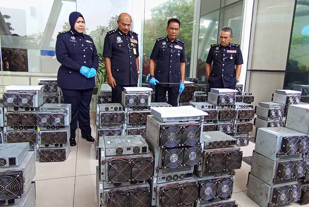 Fisol (dua dari kanan) menunjukkan sebahagian mesin bitcoin yang dirampas melalui Ops Letrik pada Khamis lepas.