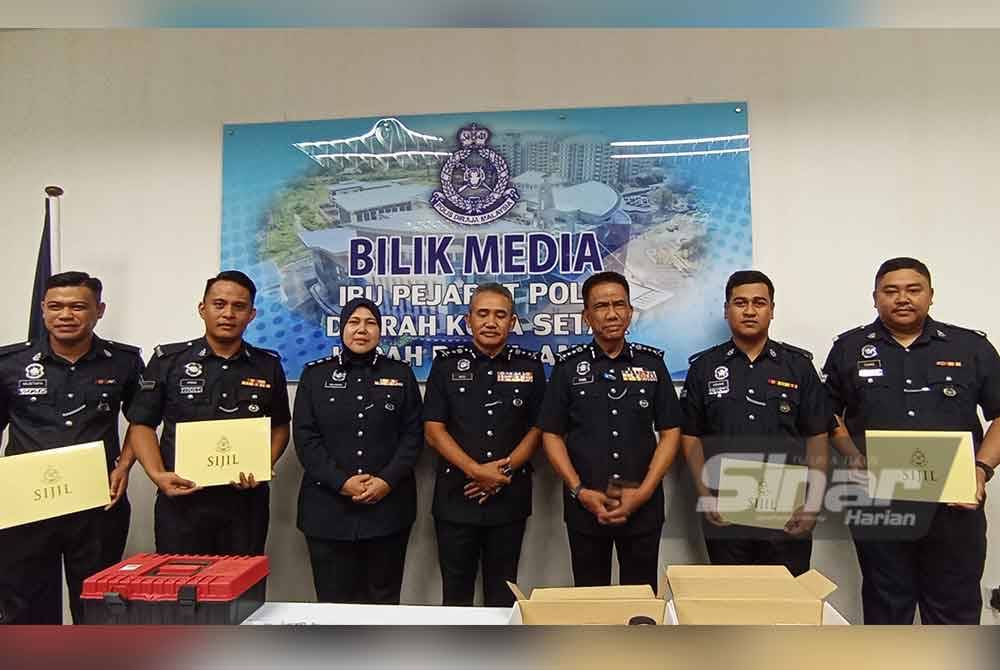 Fisol (tiga dari kanan) bersama beberapa anggota polis yang berjaya menahan seorang lelaki bersama pistol dan peluru ketika rondaan cegah jenayah di Taman Lam Foong pada Ahad lepas.