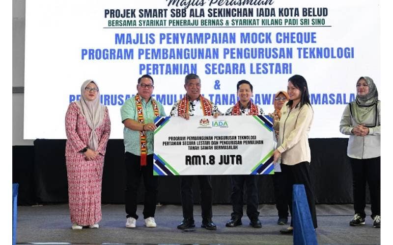 Mohamad (empat dari kanan) menyampaikan cek kepada penerima (kanan) Program Pembangunan Pengurusan Teknologi Pertanian secara Lestari dan Pengurusan Pemulihan Tanah Sawah bermasalah bernilai RM1.8 juta.