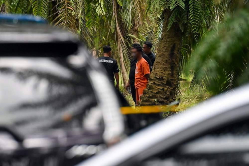 Suspek kes pembunuhan Nur Farah Kartini dibawa ke sebuah parit di ladang kelapa sawit di Kampung Sri Kledang. Foto Bernama