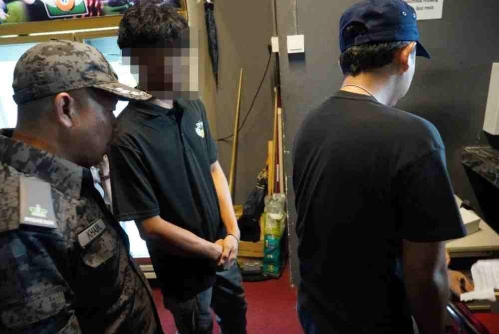 Imigresen membuat pemeriksaan terhadap warga Indonesia yang ditahan ketika cuba menyorok semasa serbuan di pusat snuker di Taman Puchong Utama, Selangor pada Rabu.