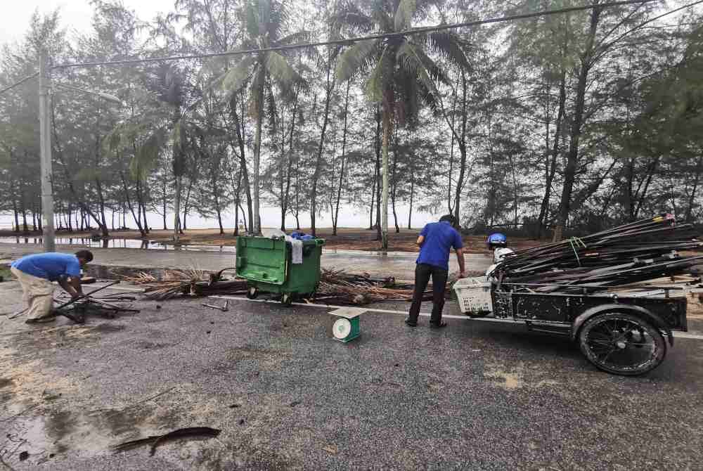 Peniaga membersihkan kawasan perniagaan di Pantai Pulau Kekabu di Marang selepas dibadai ribut.