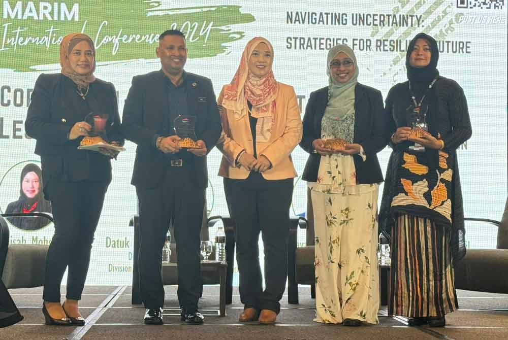 Farhah (tengah) bergambar bersalam panel jemputan yang berkongsi maklumat di persidangan tersebut.