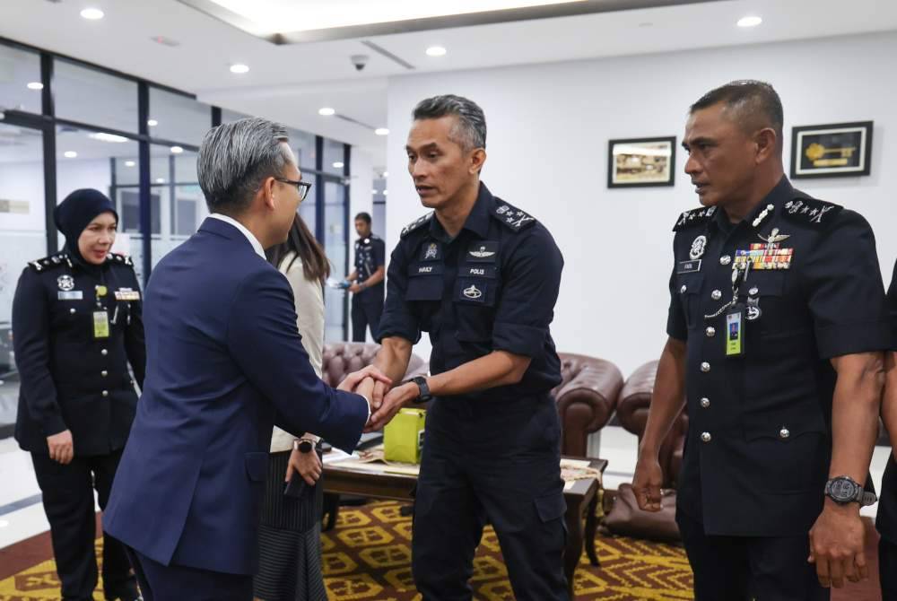 Pengarah JSJ Bukit Aman, Datuk Seri Mohd Shuhaily Mohd Zain (tengah) ketika bertemu dengan Fahmi (kiri) bagi membincangkan isu digital.