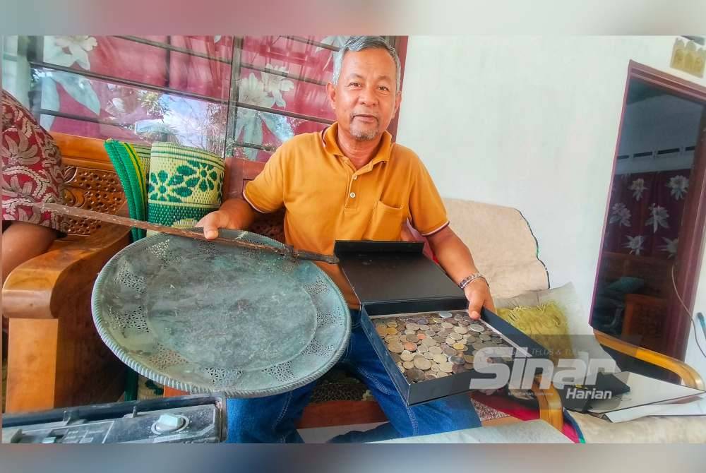 Abdul Rashid bersama dulang, lembing serta wang syiling lama miliknya.