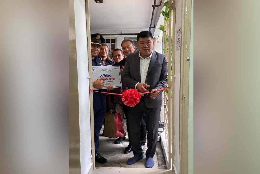 Chee Heng memotong reben sebagai simbolik perasmian Rumah RM1 Uncle Kentang.