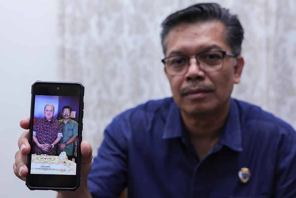 Hamdan menunjukkan gambar beliau bersama Sultan Ibrahim. Foto Bernama