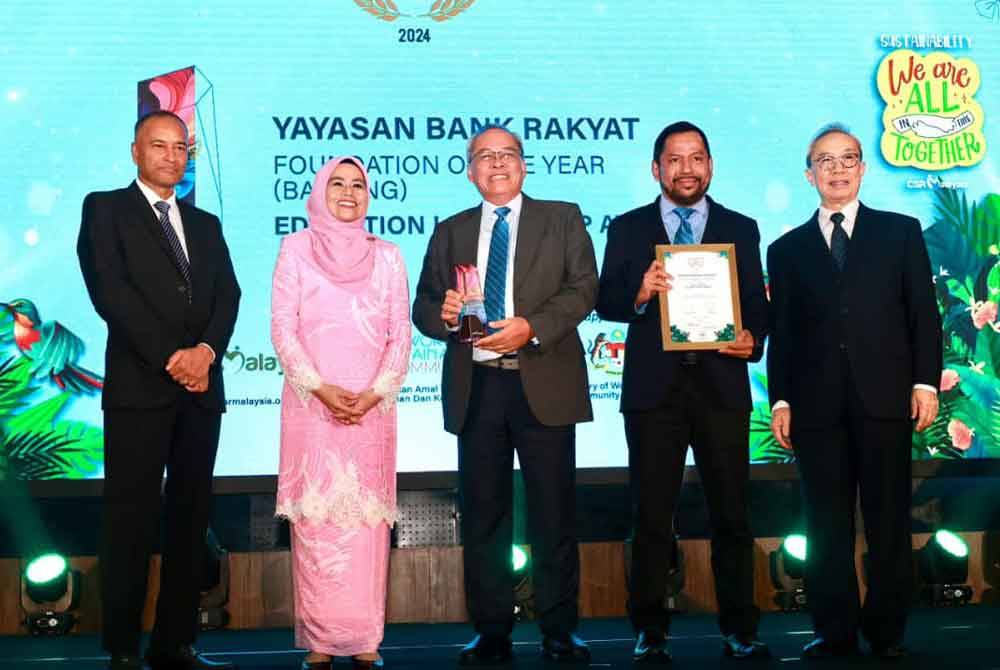 Philip (tiga dari kiri) menerima piala iringan yang disampaikan oleh Noraini.