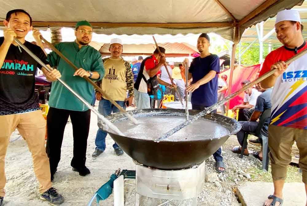 Nik Saiful Adli (dua dari kiri) bersama ahli jawatankuasa Masjid Imanul Fa'izin bergotong-royong menyiapkan bubur Asyura pada Sabtu.