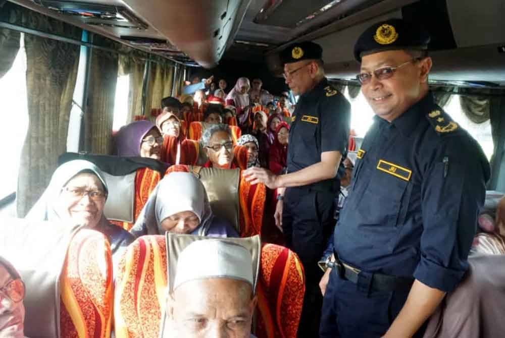 Stien Van (dua dari kanan) melakukan pemeriksaan dalam bas persiaran sempena ops khas di Plaza Tol Hutan Kampung pada Sabtu.