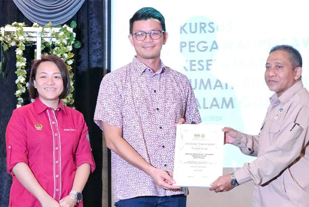 Kar Hing (tengah) menyerahkan surat penghargaan kepada Timbalan Pengarah Jabatan Mineral dan Geosains Perak, Borhan Mohamad (kanan) pada Kursus Pegawai-Pegawai Keselamatan untuk Rumah Ibadat Dalam Gua Batu Kapur di Ipoh.