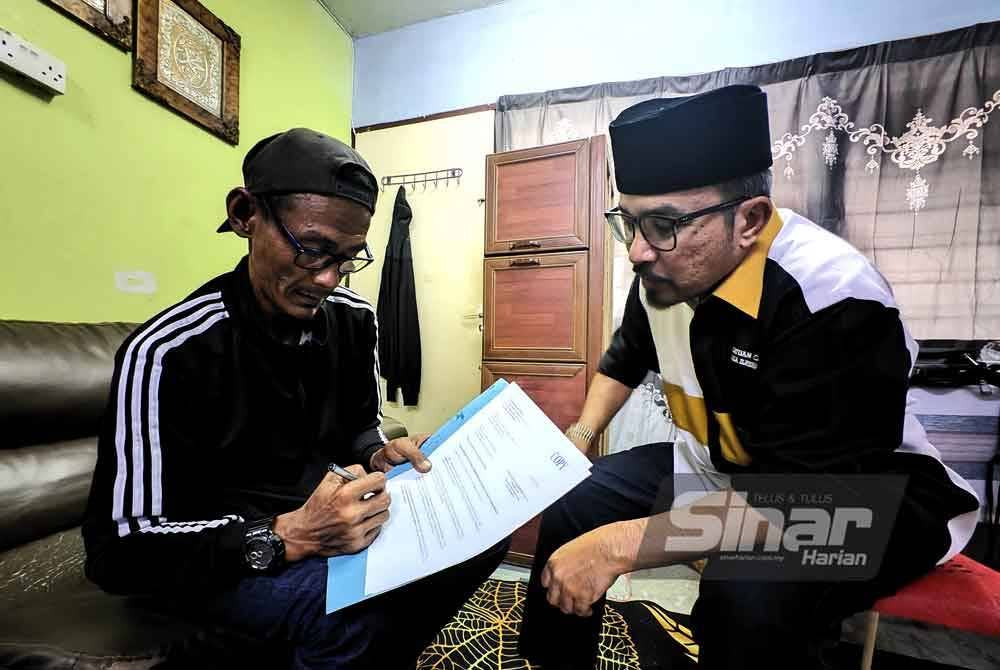 Zaidtulakmar menandatangani surat pemberhentian sebagai asnaf sambil diambil disaksikan Zulkifli.