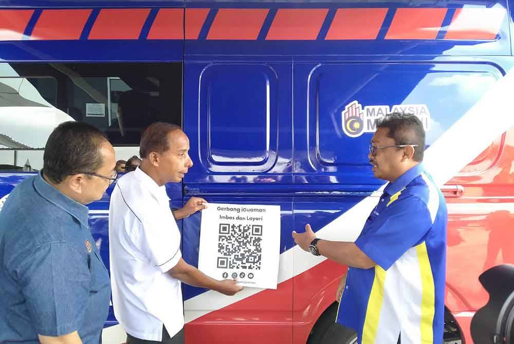 Kula Segaran (dua dari kiri) menyempurnakan gimik menampal pelekat QR pada kenderaan JoW sempena Program Hari Bertemu Pelanggan Bahagian Hal Ehwal Undang-Undang Jabatan Perdana Menteri di sebuah pusat beli belah pada Ahad