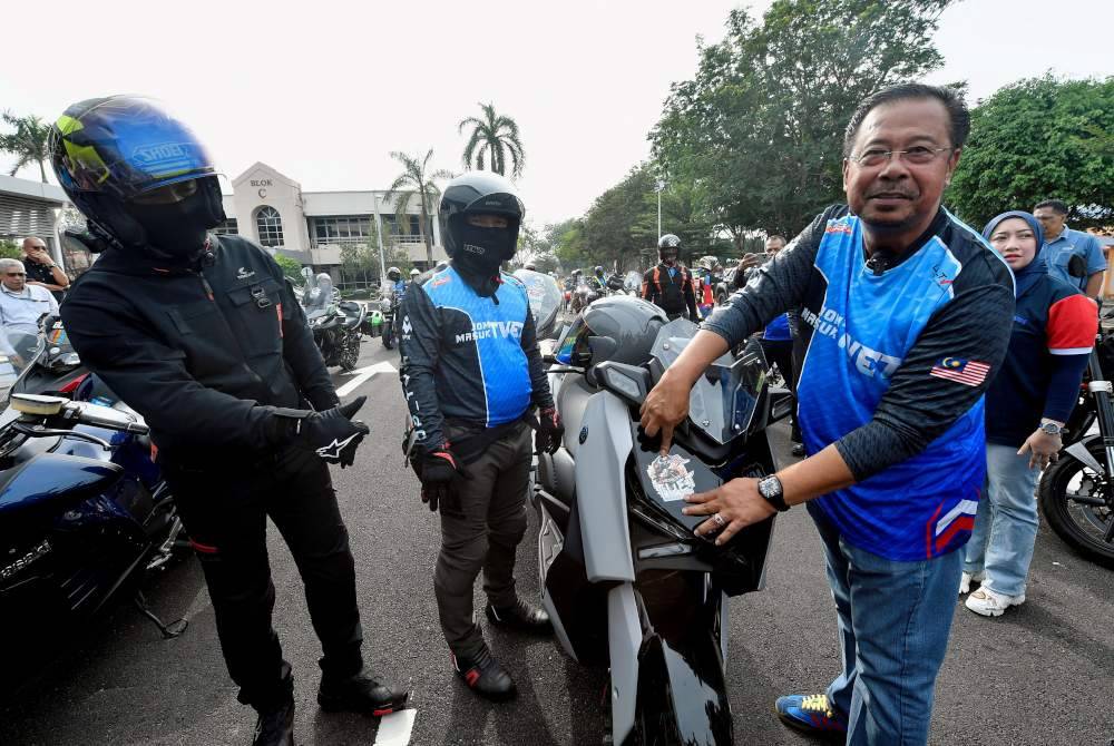 Abdul Rahman (kanan) melekatkan stiker pada kenderaan konvoi sempena Majlis Perasmian dan Pelepasan Kembara TVET Madani 2024 di CIAST Seksyen 19 pada Isnin. Foto Bernama