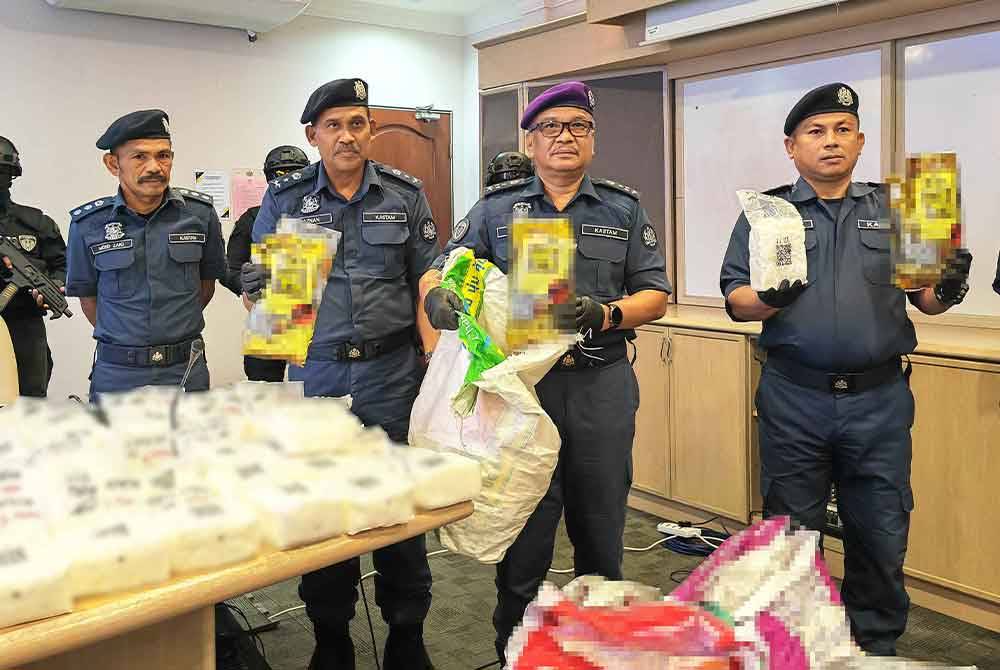 Ribuan(dua dari kanan) menunjukkan bungkusan dadah yang dirampas