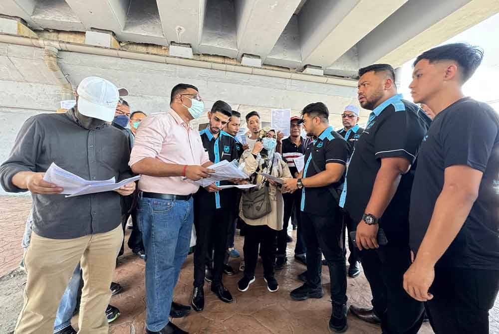 Hishamuddin (tiga dari kanan) berbincang dengan mangsa-mangsa yang membuat laporan polis di hadapan Balai Polis Bayan Lepas.