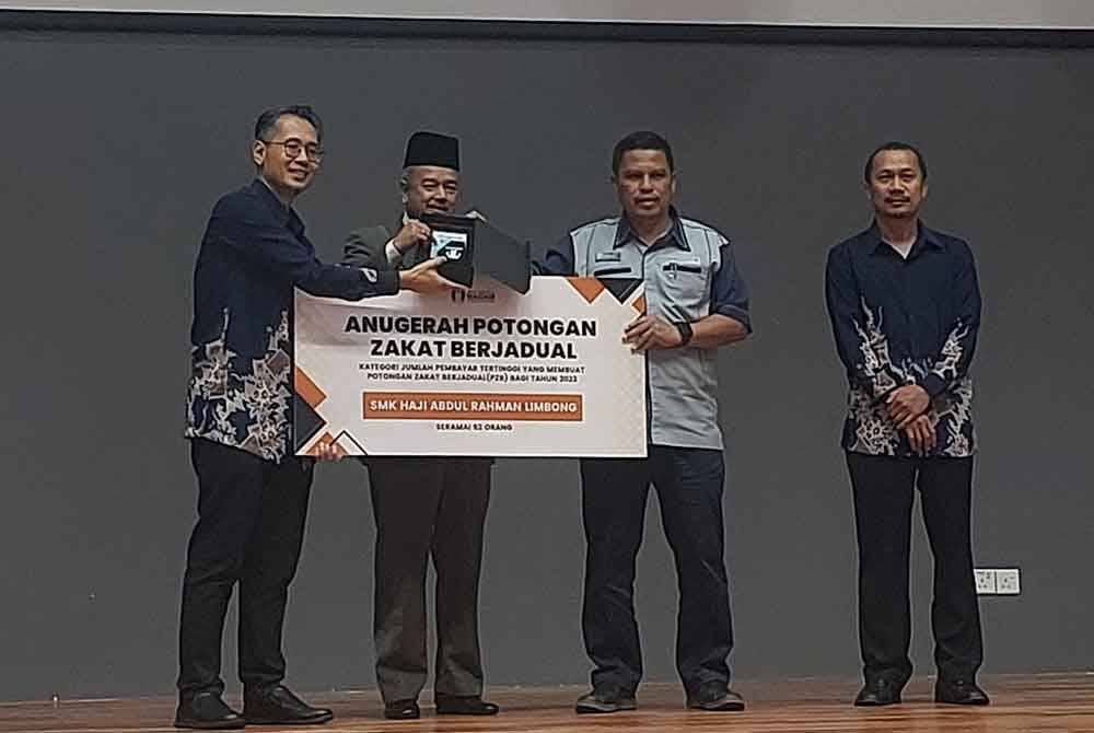 Nazli Amirri (kiri) ketika menyampaikan Anugerah Bilangan Pembayar Tertinggi Potongan Zakat Berjadual tahun 2023 kepada wakil SMK Haji Abdul Rahman Limbong