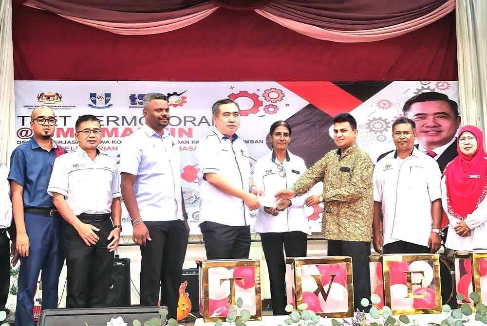 Anthony (empat dari kiri) menyampaikan sumbangan kepada Persatuan Ibu Bapa dan Guru SMK Mantin.