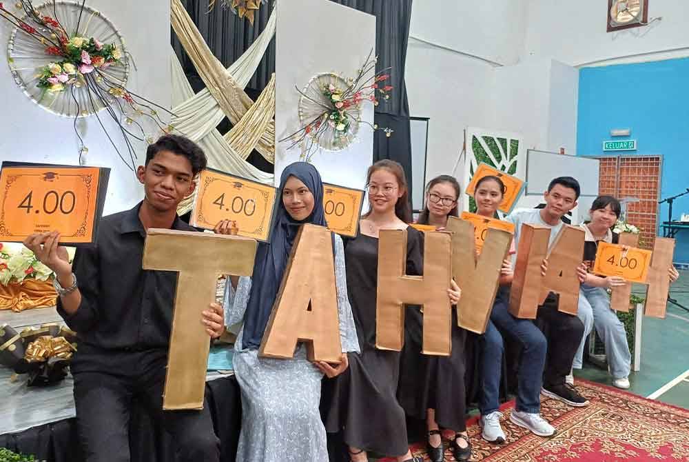 Ammar (kiri) dan Aienur Salmalisa (dua dari kiri) bersama lima lagi yang meraih PNGK 4.00 dalam keputusan STPM 2023 di SMK Astana pada Selasa.