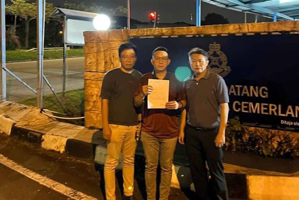 Thow Siang (tengah) menunjukkan salinan laporan yang dibuat berkenaan ugutan diterima di Balai Polis Desa Cemerlang, Johor Bahru