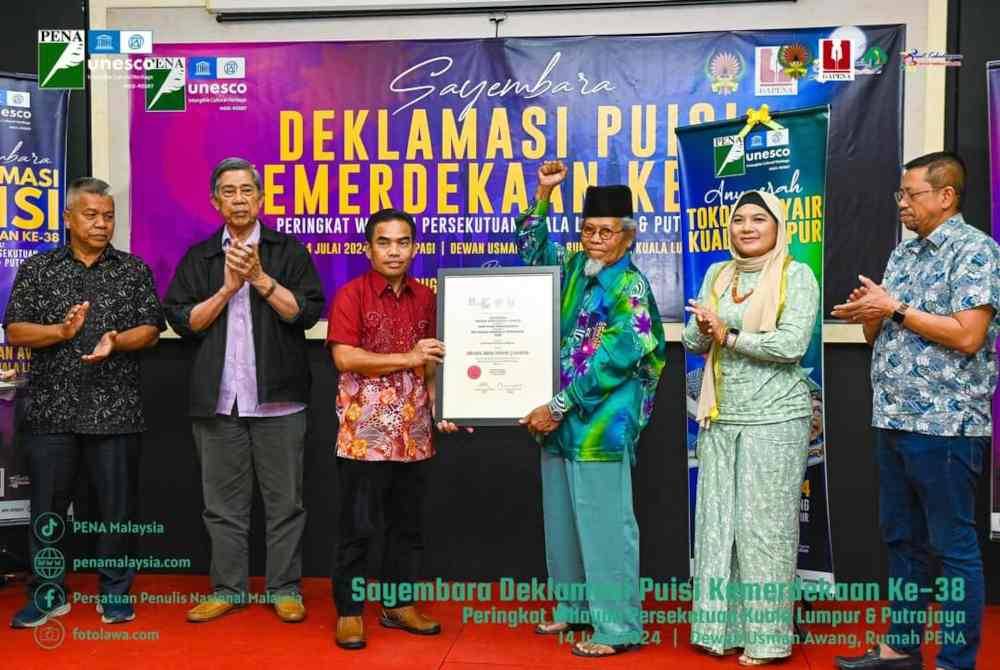 Ketua Pengarah Dewan Bahasa dan Pustaka, Dr Hazami Jahari (tiga dari kiri) menyampaikan anugerah Tokoh Penyair Wilayah Persekutuan Kuala Lumpur dan Putrajaya 2024 kepada Ibrahim (tiga dari kanan).