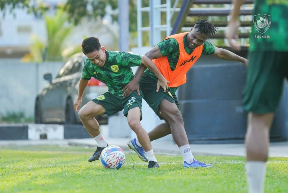 Penyerang KDA FC, Ebenezer Assifuah (kanan) antara tonggak yang turun berlatih pada sesi latihan di Jitra pada Rabu. Foto KDA FC